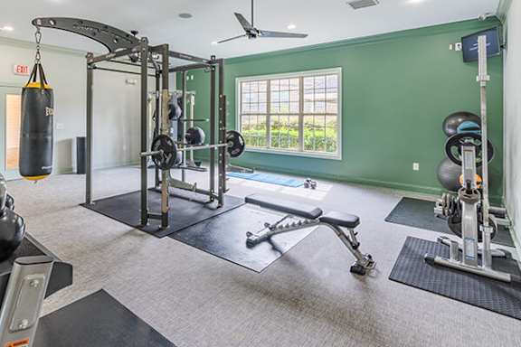 A gym with a punching bag, weights, and exercise equipment.