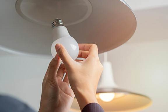 A person is changing a light bulb.