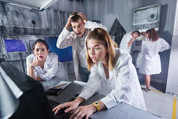 A group of people in a lab setting looking at a computer screen.