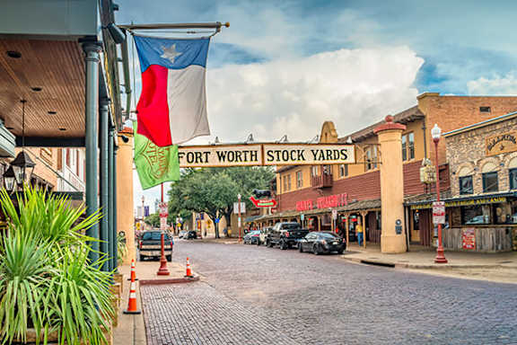A street view of Fort Worth Stock Yards with Texas flag.