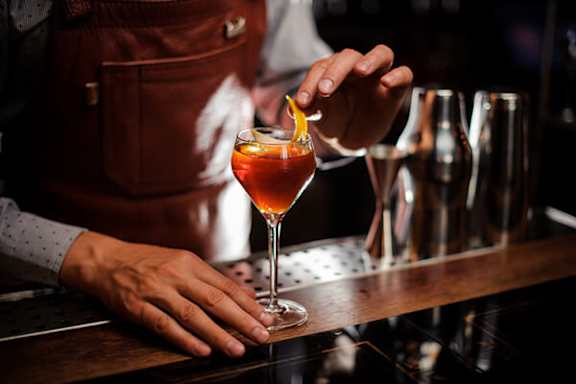 A bartender is making a drink in a bar.