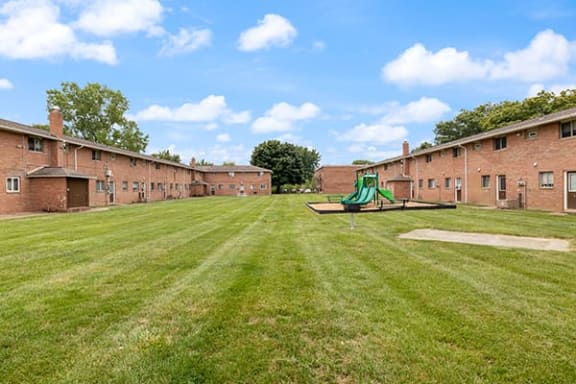 a green playground in the middle of a brick building
