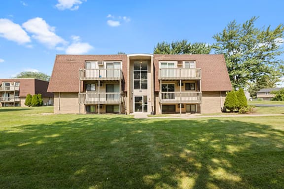 a large apartment building with a green lawn