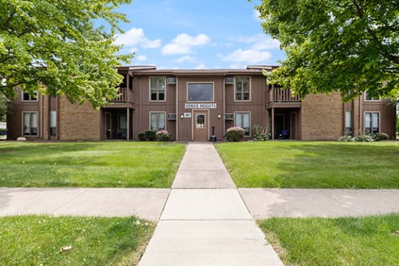 a large brick building with a sidewalk in front of it