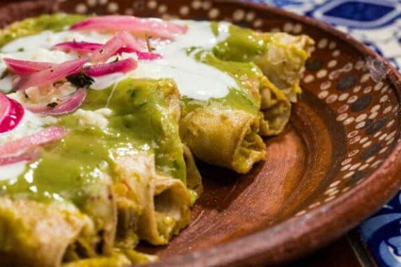 a plate of food with green sauce and onions on it