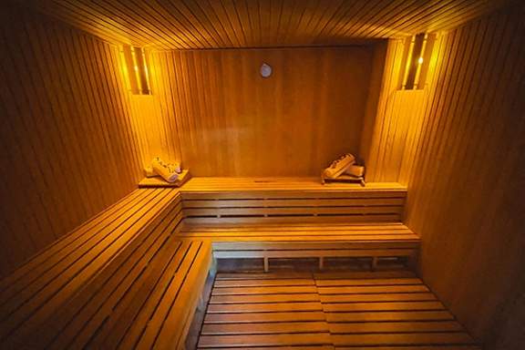 A wooden sauna with benches and lights.
