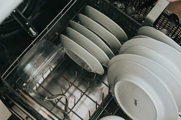 Plates are stacked in a dishwasher.