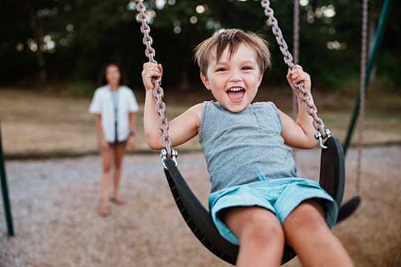 A young child is swinging on a swing set.