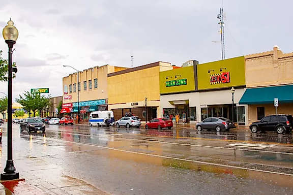 A street with cars and buildings on either side.