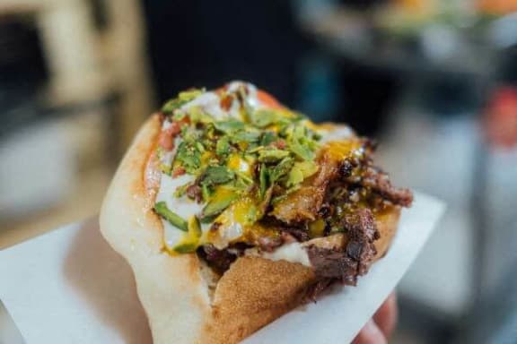 a sandwich with meat and vegetables on a napkin