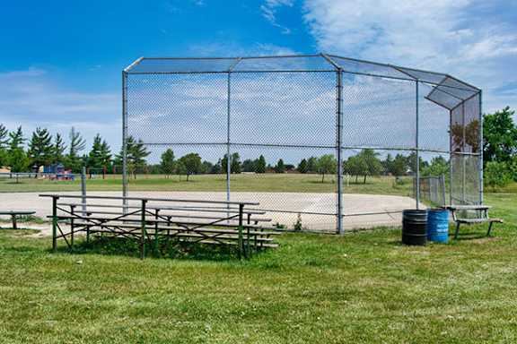 A fenced area with picnic tables and a trash can.