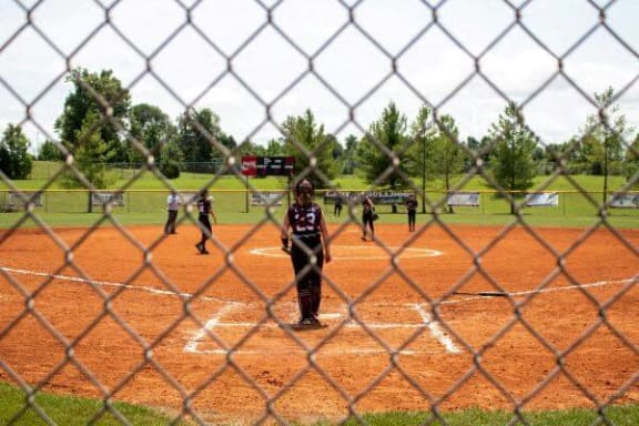 a group of baseball players on a field behind a fence