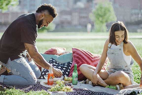 A man and a woman are having a picnic in a park.