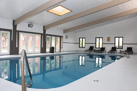 A large indoor swimming pool with a diving board and lounge chairs.