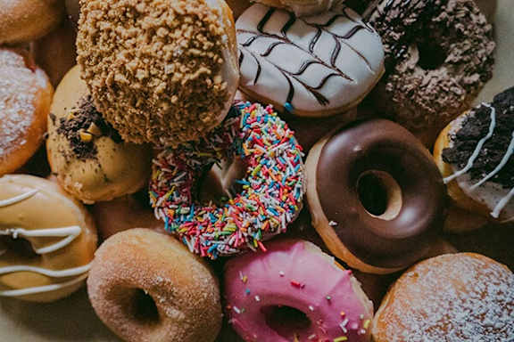 A close up of a variety of donuts with different toppings and flavors.