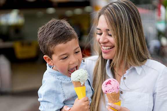 A woman and a boy are enjoying ice cream cones.