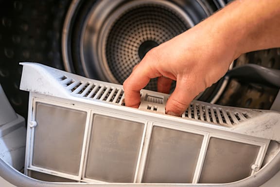 A person's hand is touching a car air filter.