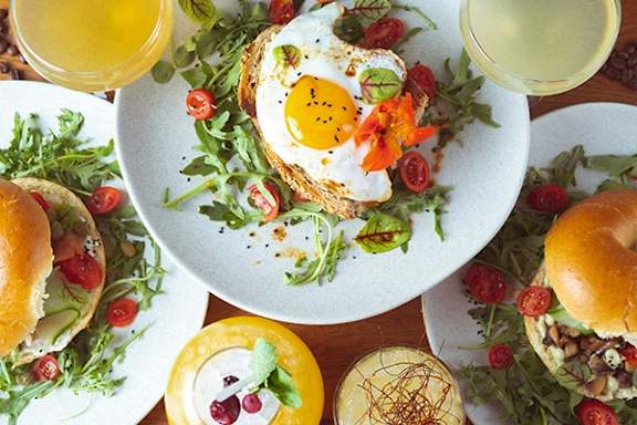 A breakfast spread with eggs, salad, and juice.