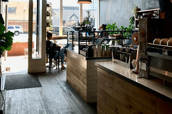 A person is sitting at a wooden counter in a brightly lit room.