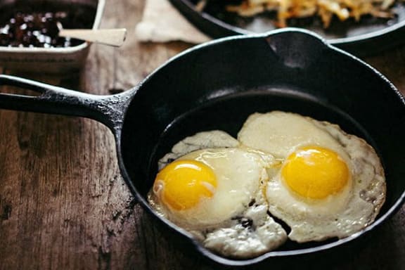 two eggs in a cast iron skillet on a table