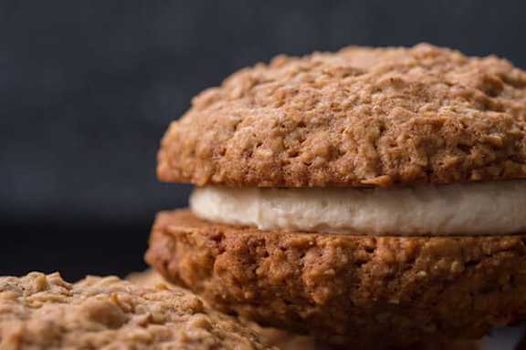 A close-up of a stack of oatmeal cookies with a cream filling.