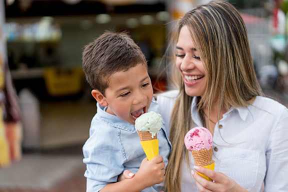 A woman and a child are enjoying ice cream cones together.