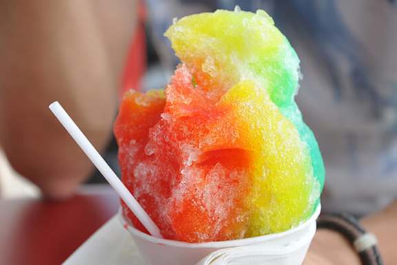 A rainbow shaved ice dessert in a cup.