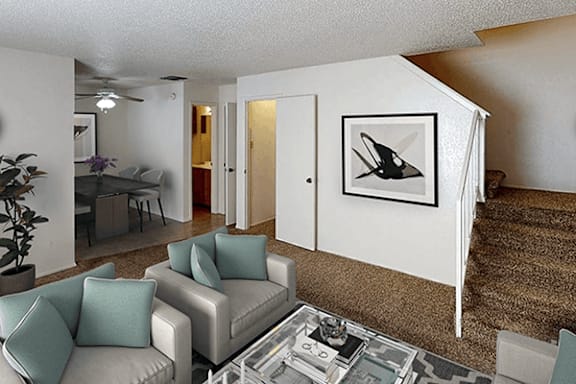 A living room with a grey couch and a painting of a bird on the wall.