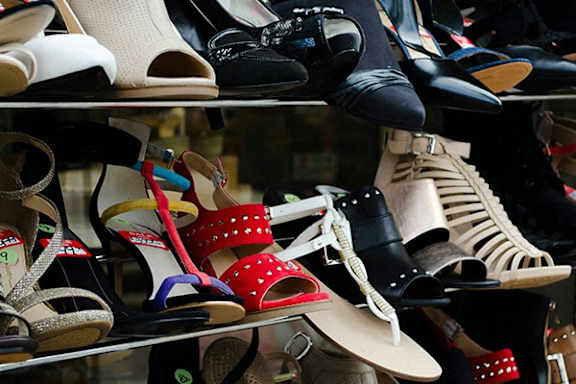 A variety of shoes are displayed on shelves.