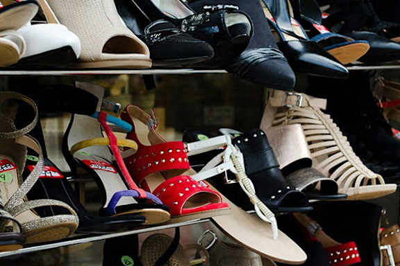 A variety of shoes are displayed on shelves.