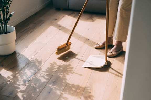 A person sweeping the floor with a broom.
