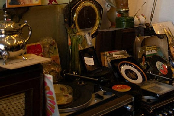 a cluttered desk with a mirror and other items