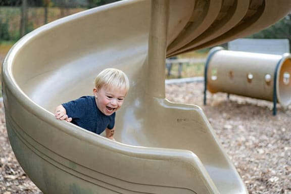 a little boy is going down a slide