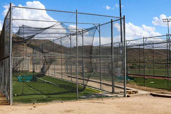 A baseball field is enclosed by a chain link fence.