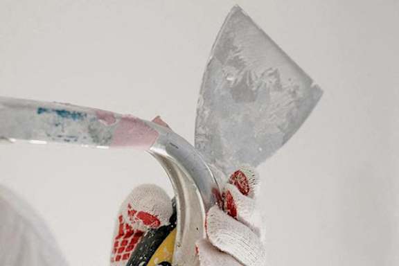 A person is holding a broken glass with a white cloth.