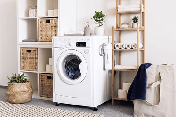 a white washer and dryer sitting next to a white shelving unit