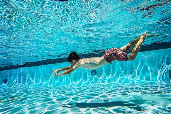 a man swimming in a swimming pool