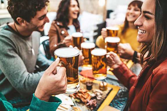 A group of people enjoying beer together at a table.
