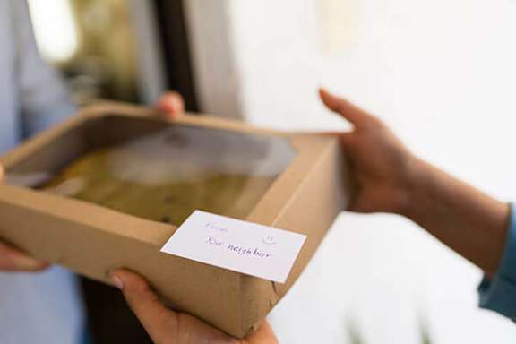 A person is holding a box with a note that says "For Heather".