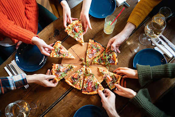 A group of people sharing a pizza at a table.