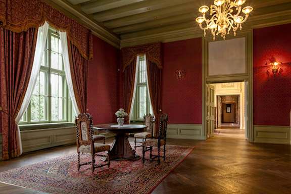 A room with red walls and a chandelier.