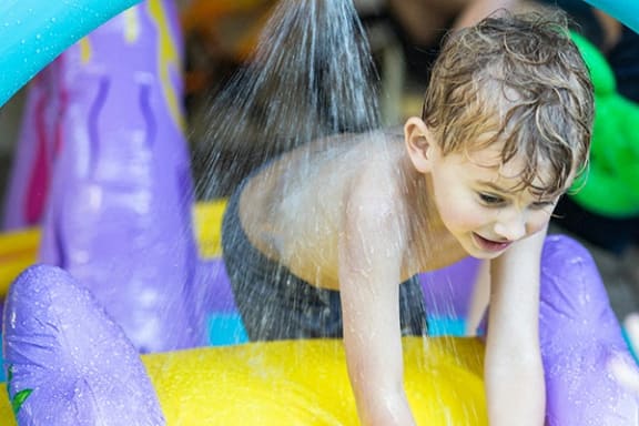 a young boy playing in a water slide