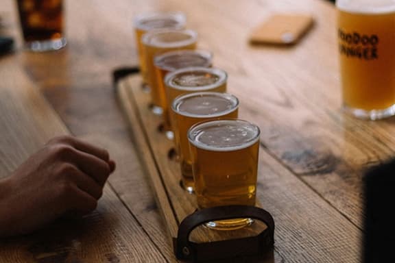 a row of beer glasses on a wooden table