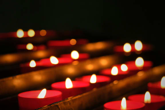 a group of red candles lit up in a dark room