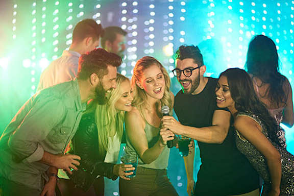 A group of people are gathered around a microphone, with one person holding a water bottle.