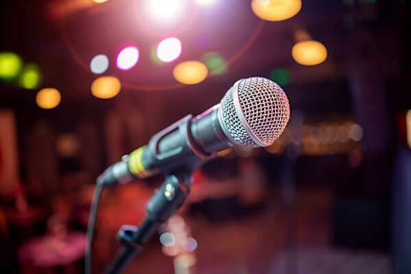 A microphone on a stand with a blurred background.