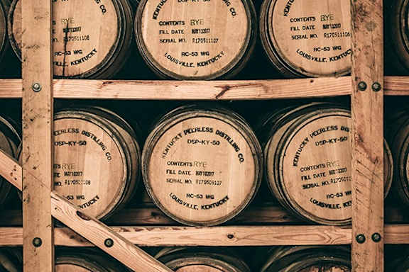 A stack of wooden barrels with labels reading "Continues Rye".