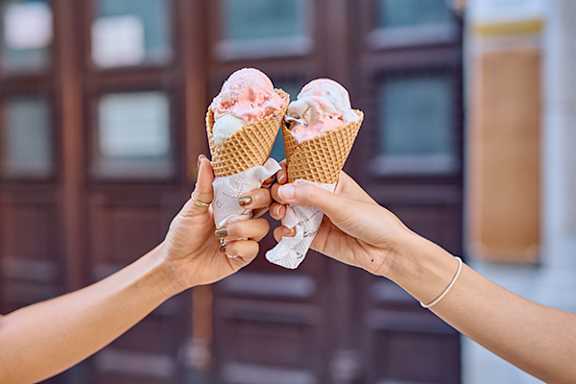 Three women enjoying ice cream cones outdoors.
