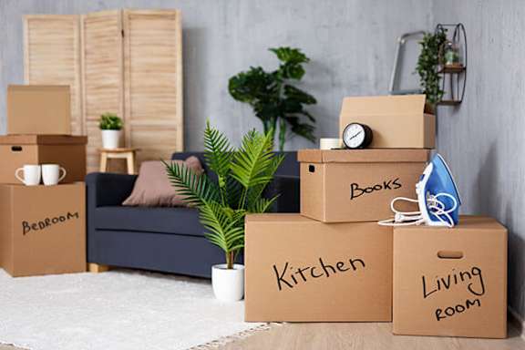 A set of moving boxes are labeled Bedroom, Kitchen, Living Room, and Books.