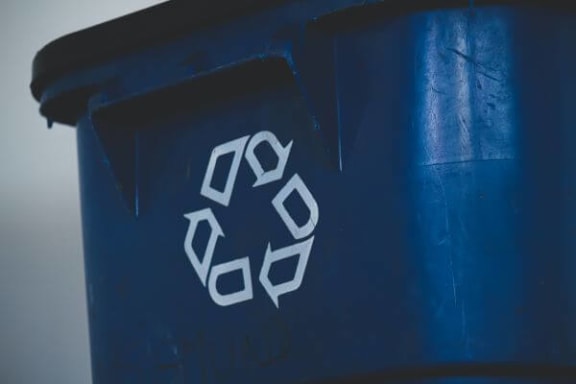 a blue trash can with a recycle symbol on it